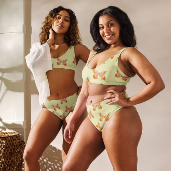 Two women wearing a high-waisted bikini set with a pastel butterfly print on a light green background. The eco-friendly swimwear features a flattering fit and sustainable fabric.